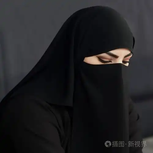 阿拉伯年轻妇女的画像从卡塔尔在传统伊斯兰教的布料面纱反对在黑暗的