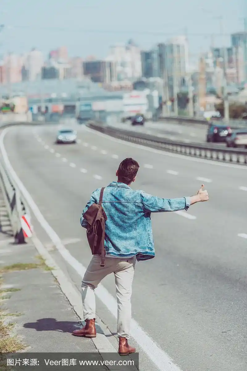 独自在路上搭便车的男人的背影