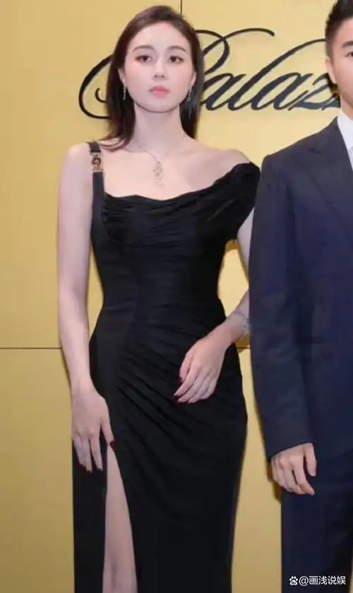 因此在整张大合照中,穿了一件黑色高开叉抹胸礼服的何超欣,一眼就让人
