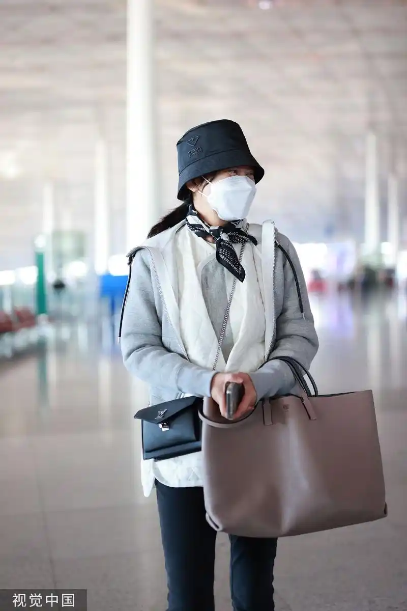 组图:闫妮戴渔夫帽现身机场 穿灰色外套休闲简约眼神温柔