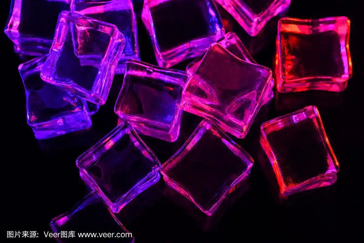 冰块在黑色背景与粉色和紫色的背光.照亮冰块.宏观水平摄影