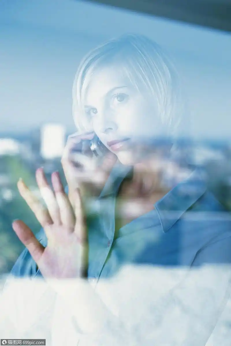 在玻璃窗后面打电话的女人