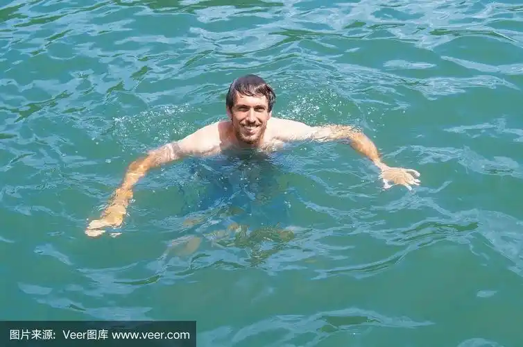 漂亮的年轻人游泳或踩水在湖里