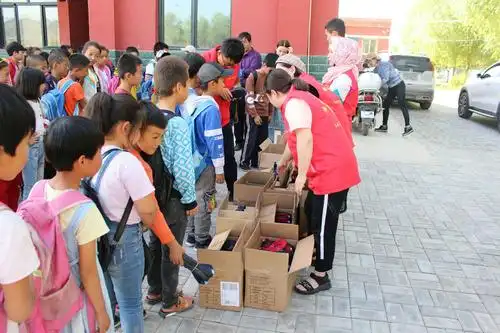 志愿者为孩子们发放爱心布鞋