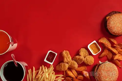 肉汉堡,薯条和饮料在红色背景上的玻璃.外卖的组成