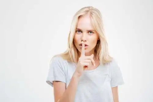 漂亮的金发女人做着小声的手势