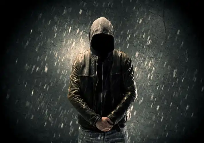 淋雨戴帽子低头的男人