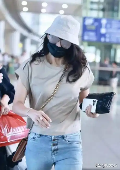 章子怡机场亮相,灰色的t恤搭复古风牛仔裤,潇洒迷人气质出众.