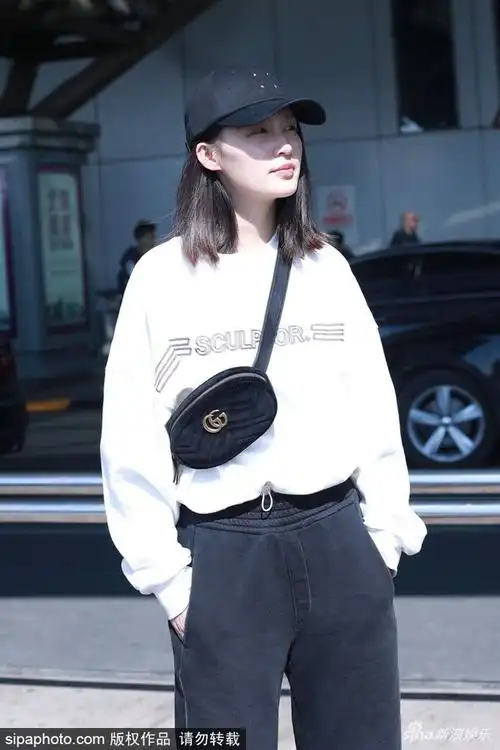 组图:李沁斜挎潮包黑白配时尚 变"低头族"手机看不停