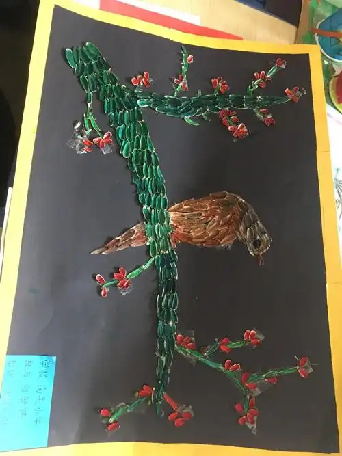 这是一幅喜鹊登梅的手工作品,材料是废瓜子皮,是绿色环保的创意
