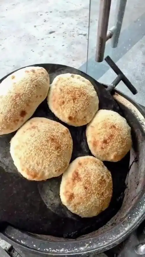 铁板转来转去,不到十分钟,芝麻烧饼就出锅了