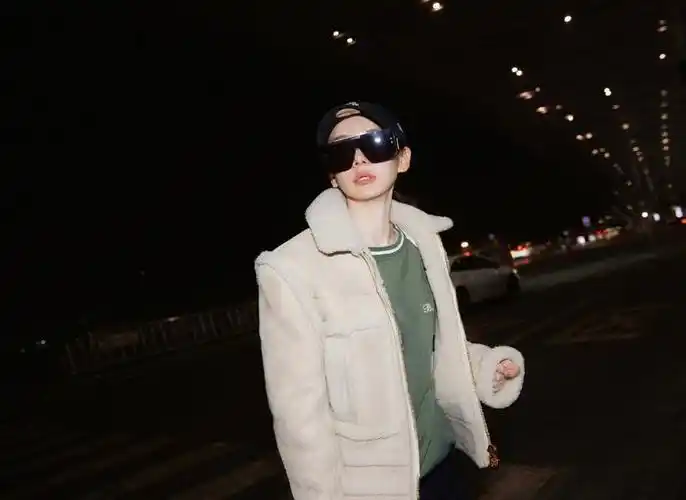 戚薇身穿绿色内搭外穿白色夹克现身机场黑白拼接手提包