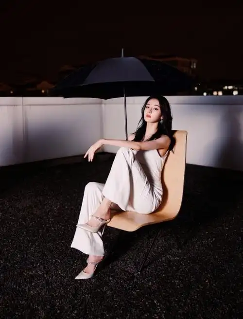 热巴穿斜肩连体裤撑黑伞 眼神霸气酷飒十足