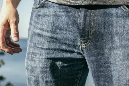 背面的男人小便站一个穿着湿牛仔裤的男人站在海滩上照片