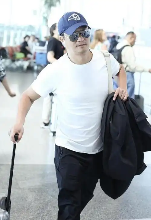 吴京一身白衣黑裤潇洒走机场,走路有范儿引路人围观_身材