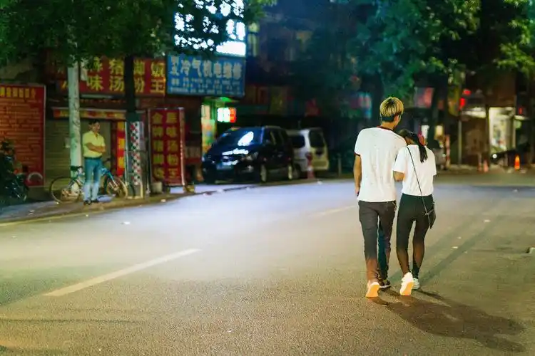 某个夜晚,一对情侣依偎着步行在街道上.