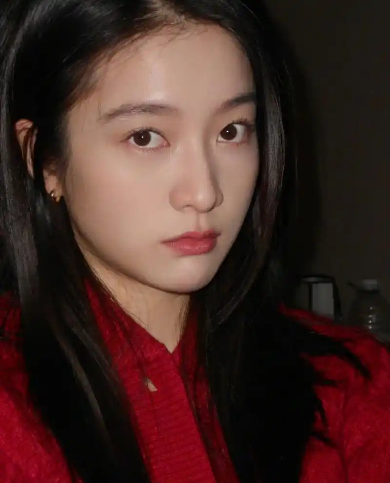 张雪迎晒自拍,白玫瑰配红色毛衣港风感十足,她很会营造文艺氛围,清冷