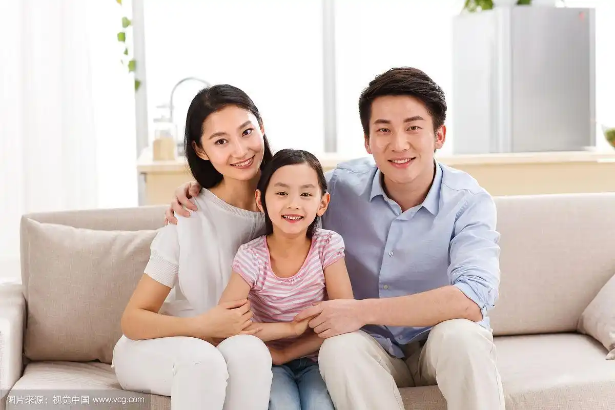 幸福的一家三口坐在客厅的沙发上