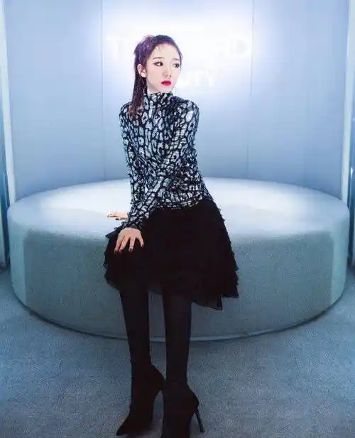 斑驳纹路上衣搭配黑色半裙,脚上是黑色高跟鞋,孟美岐的妆容是比较艳丽