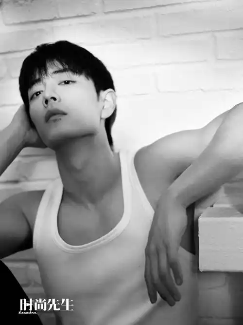 肖战身穿白色背心席地而坐,肩膀的肌肉和身材曲线备加吸睛,穿着带帽