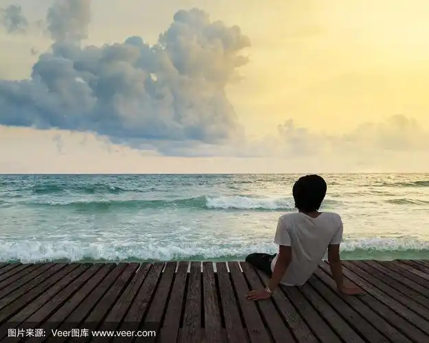 悲伤的人坐在海边.关于人,悲伤和孤独的概念