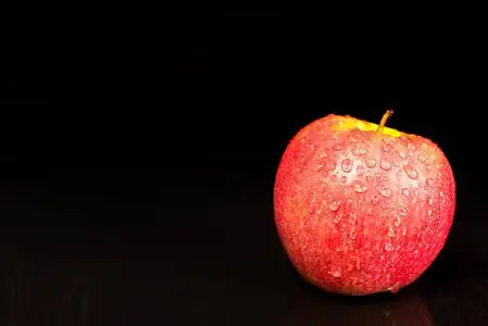 深色背景上的水滴中的红苹果,文本的位置照片