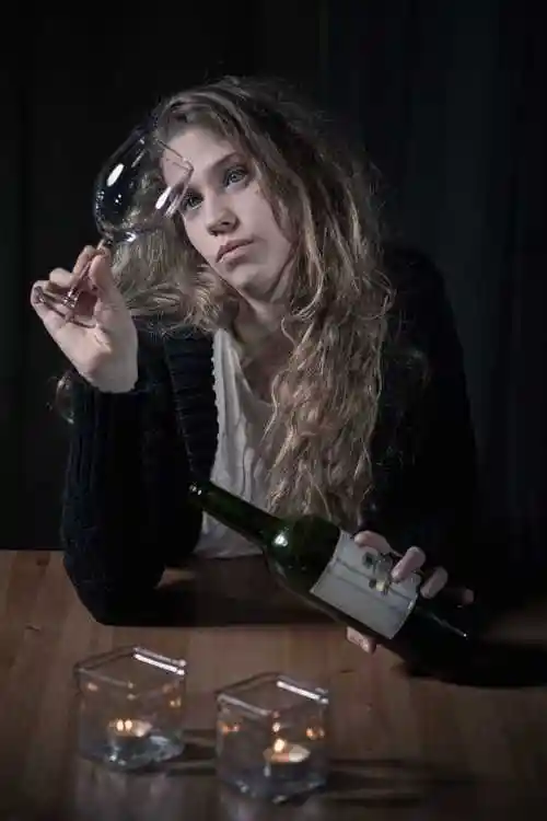 在室内喝酒的悲伤的女人