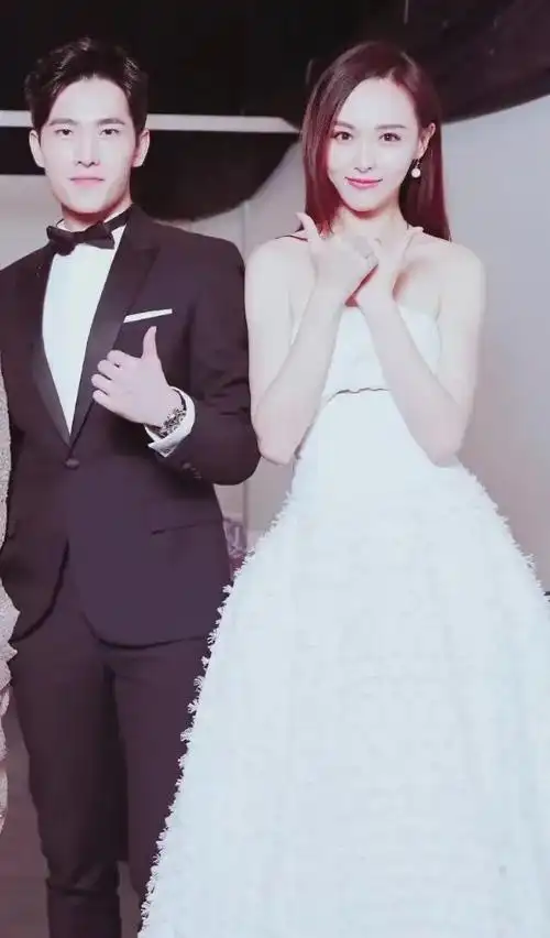 唐嫣和杨洋挽手同行杨洋西装帅气挺拔唐嫣白色抹胸裙端庄优雅