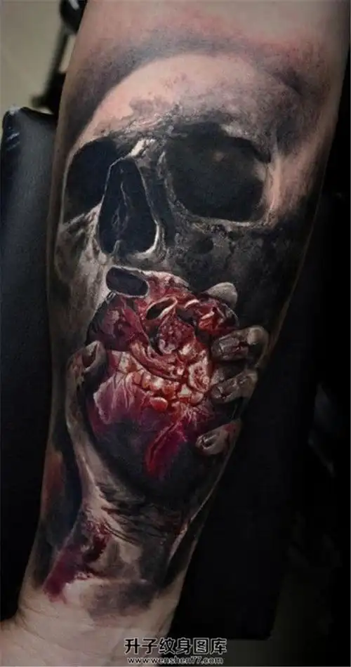 男性小臂骷髅手握心脏的血腥纹身