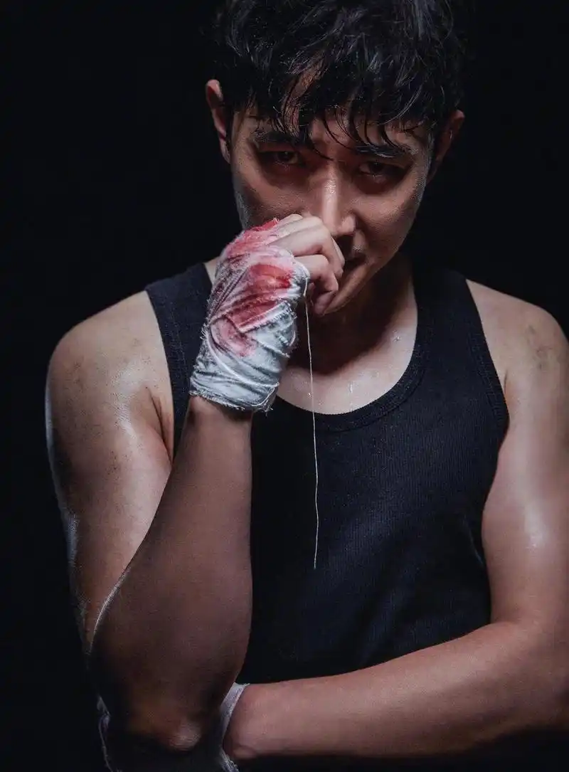 照片中罗晋身穿黑色背心,头发微湿,绷带沁血,手臂肌肉被汗水渗透后更