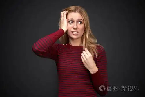 工作室肖像一个美丽的年轻的金发女郎令人不安的心烦震惊的表情在她的