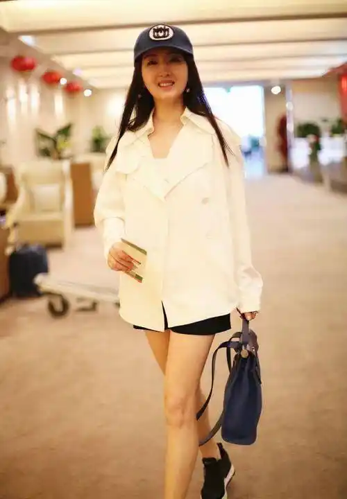"玉女"杨钰莹现身机场,48岁的她虽然容颜未老,但是略显发福_棒球帽