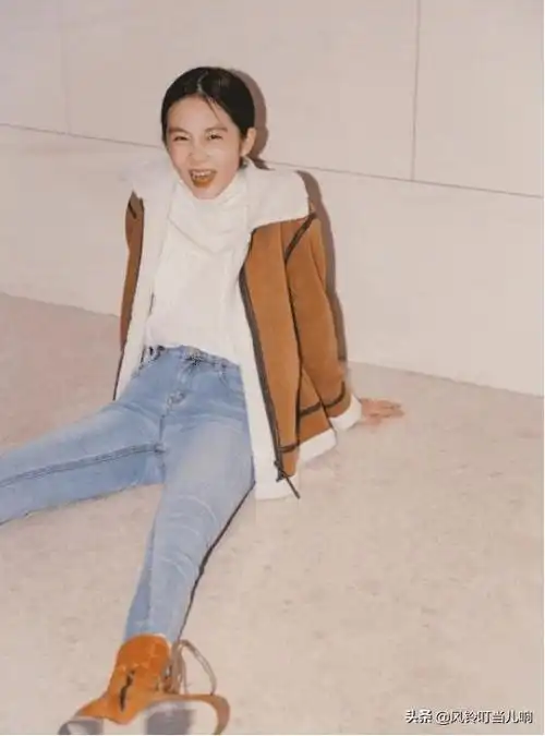 着一条浅蓝色的修身牛仔裤,卡其色的外套与脚上的马丁靴颜色十分搭配