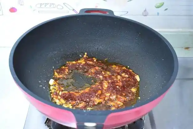 第五步 炒锅放入油,加入姜蒜蓉和一大勺豆瓣酱,把豆瓣酱炒出红油.