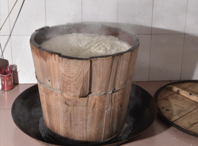 再将糯米置于木桶蒸笼内,以100℃蒸至糯米无硬心时.