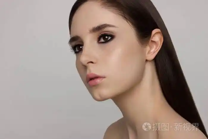 特写美女与干净的光泽皮肤和黑暗的烟雾阴影棕色的眼睛和头发.