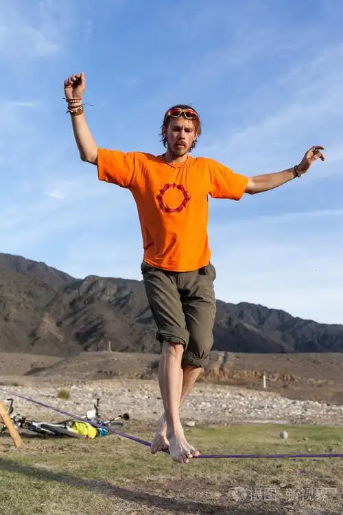 在日落时分在吊带上行走的人