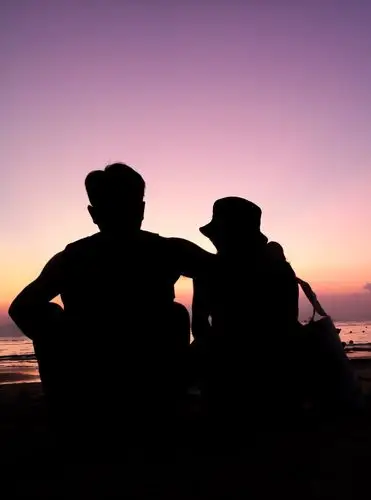 情侣在海边看日落,唯美的剪影