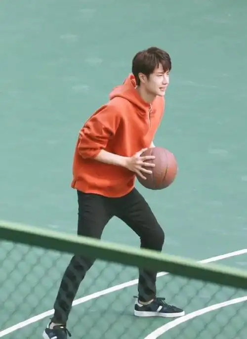 王一博打篮球被拍橘色卫衣搭配小黑裤看起来超有活力