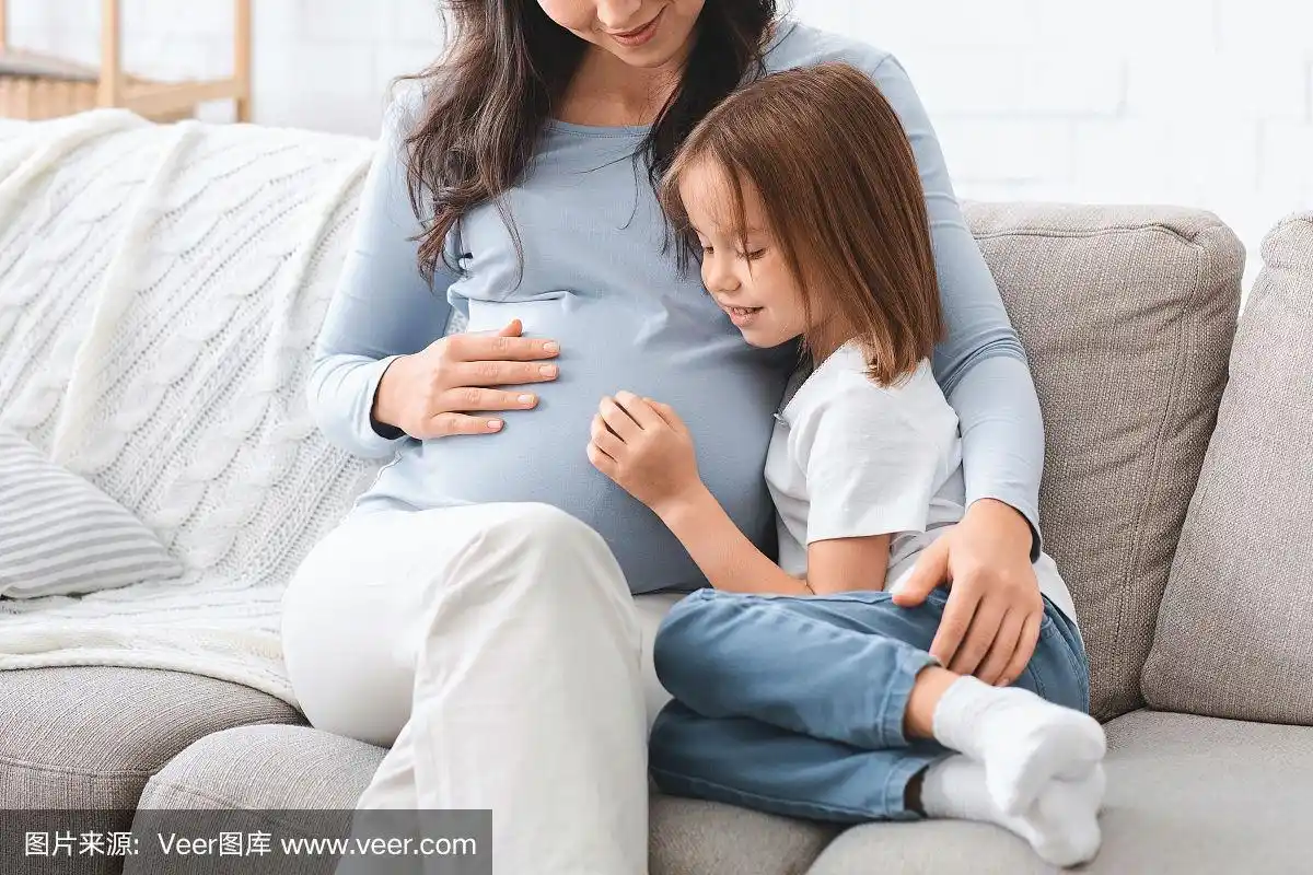 幼稚园女孩抱着她怀孕的肚子