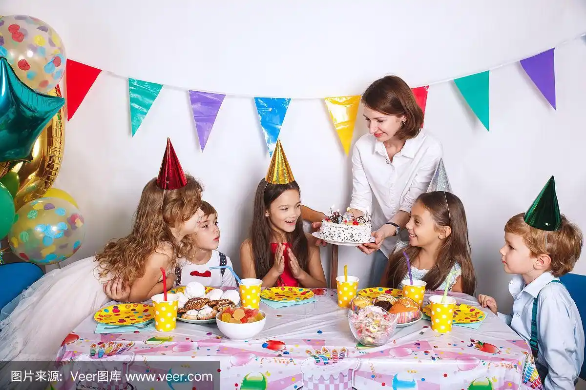 家庭生日聚会.女孩和她的兄弟姐妹吹蜡烛