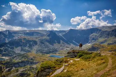 一个人从山顶欣赏美丽的景色.在山里旅行.照片