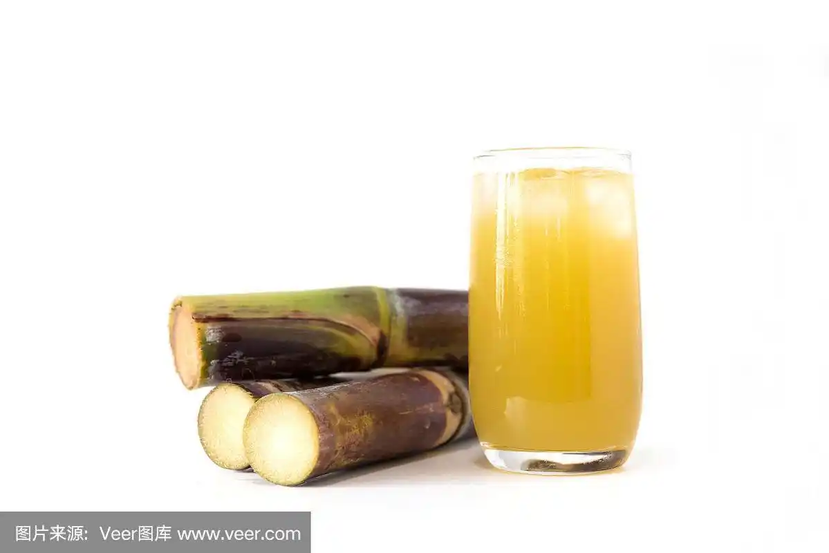 在白色背景上的玻璃杯中倒入新鲜的甘蔗汁