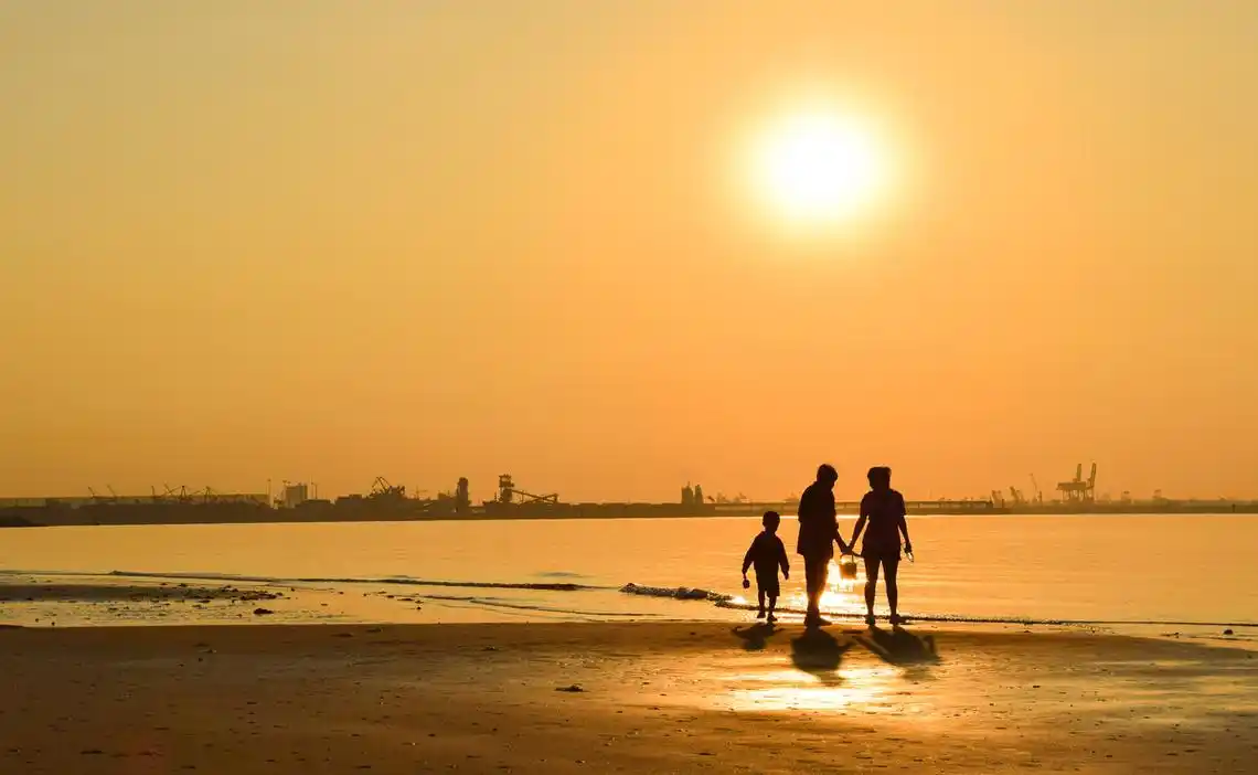 清晨的海边一家三口在晨光中好让人羡慕