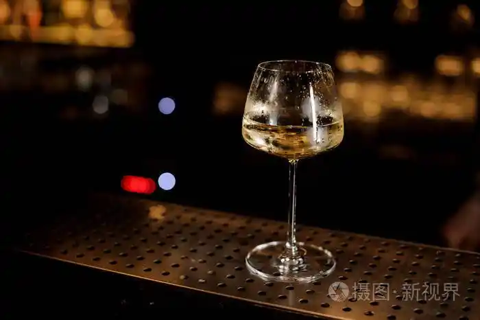 站在酒吧柜台上的白葡萄酒杯