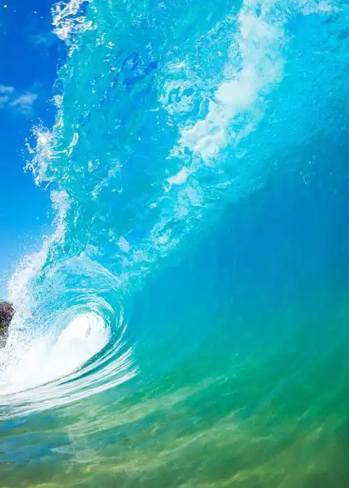 蓝色背景下翻滚的蓝色海浪和白色水雾