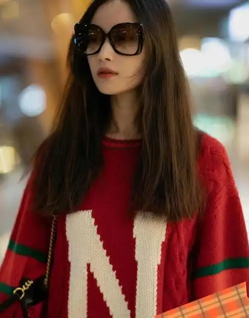 倪妮机场街拍:红色毛衣搭修身蓝色牛仔裤,简约又时尚