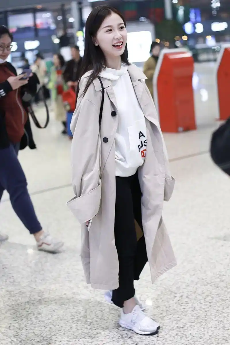 近日,虞书欣现身上海机场,身穿简约纯色风衣外套,内搭印花连帽卫衣,下