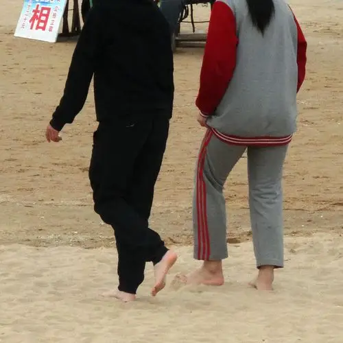年轻人赤脚体验海边揉揉软软细沙颗粒的幸福感