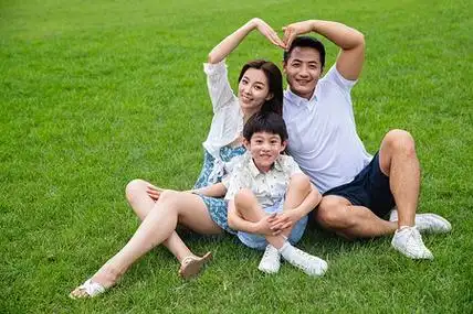 快乐的一家三口坐在草地上